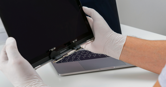 Hands holding a MacBook for Repair