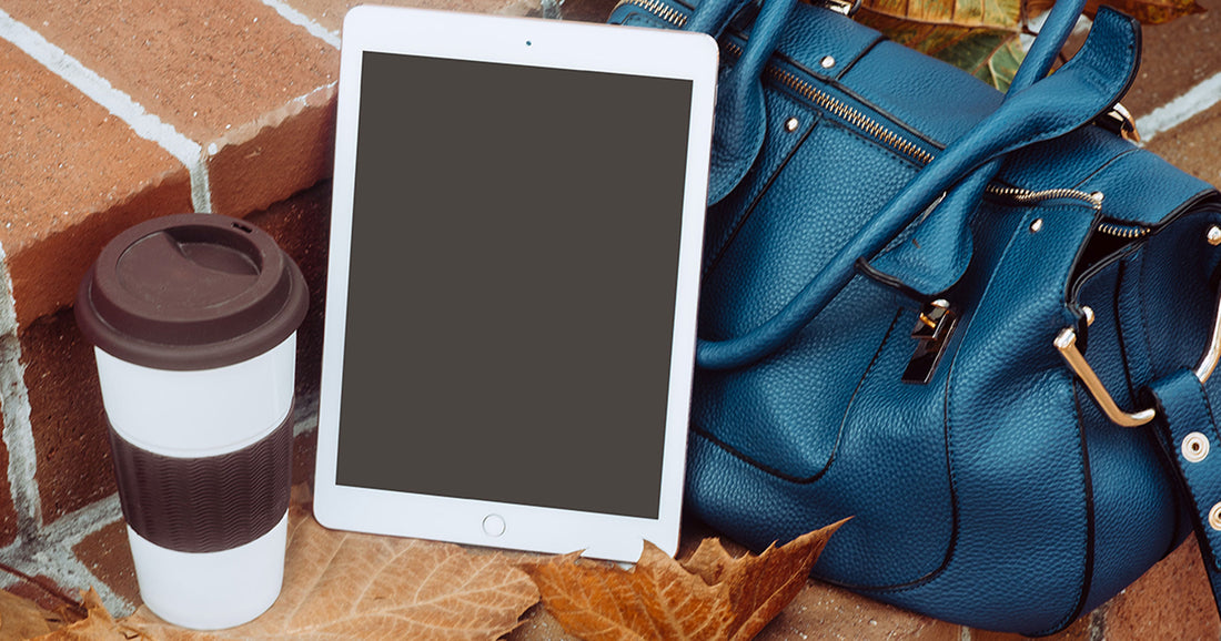 iPad beside coffee cup and handbag